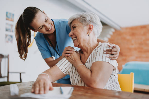 медицинский работник по уходу на дому обнимает пожилого пациента - senior adult home caregiver help care стоковые фото и изображения