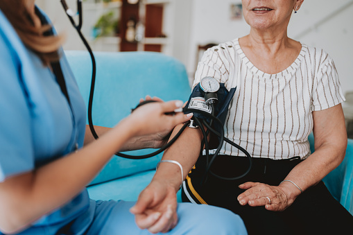 Home care healthcare professional measuring blood pressure