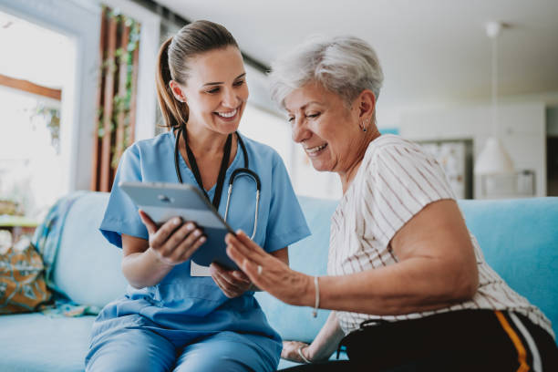 home care healthcare professional using digital tablet - female nurse nurse scrubs female doctor imagens e fotografias de stock