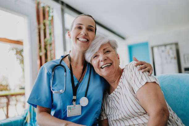 home care healthcare professional hugging senior patient - ouderenzorg stockfoto's en -beelden