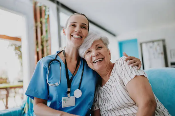 Photo of Home care healthcare professional hugging senior patient