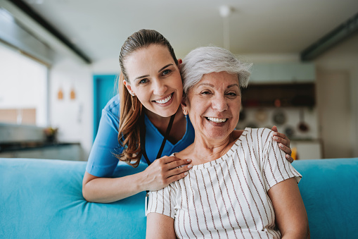 Home care healthcare professional hugging senior patient