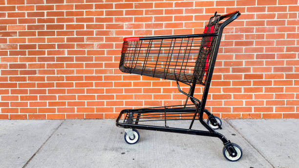 istock Empty shopping cart outside with brick background and copy space 1719550775