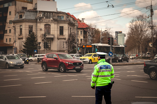 Picture of a Romanain police forces officer standing in Bucharest, in Romania. These are part of the National police units of the country, in charge of general law enforcement. The Romanian Police is the national police force and main civil law enforcement agency in Romania. It is subordinated to the Ministry of Internal Affairs and it is led by a General Inspector with the rank of Secretary of State.