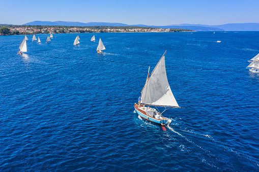 Regatta of classic sail boats in front of Malinska Village, Krk Island, Croatia, aerial view