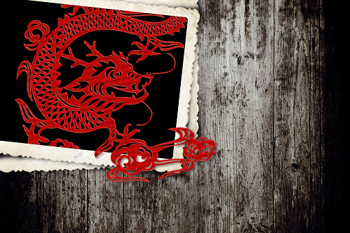 Paper-cut dragon in old instant photo frame with Year of the Dragon  in 2024