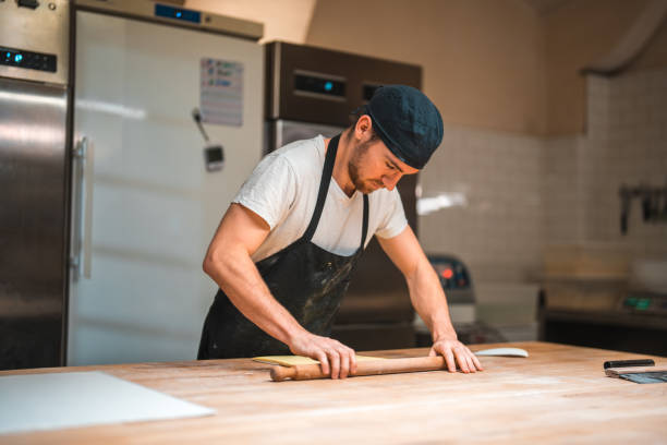 istock Caucasian Artisan Baker Rolling Butter Wrapped In A Baking Paper 1719690292