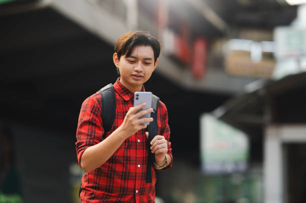 istock Asian Young Chinese university student using device in city. 1719722226