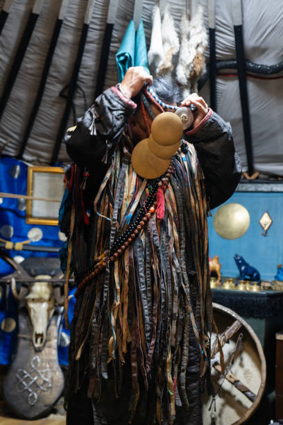 Ulaanbaatar, Mongolia - October 3, 2023: A shaman wears a necklace used during a seance at his shrine inside a ger (yurt).