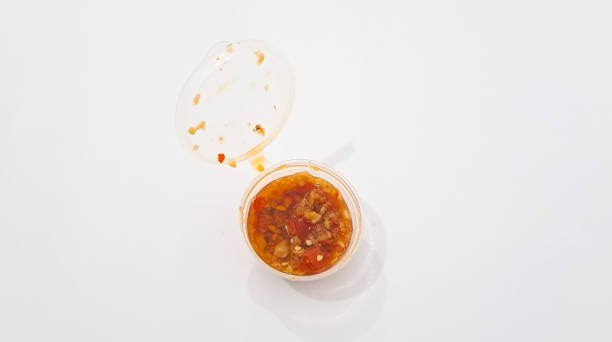 istock Red hot chilli pepper sauce in plastic cup isolated on a white background 1719746557