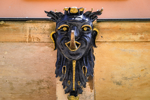 Carved wooden black gilded face with a tongue out on an old traditional half timbered house in the historic center of Strasbourg, Alsace, France