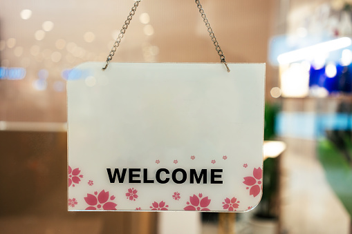 View through window of welcome sign in shop