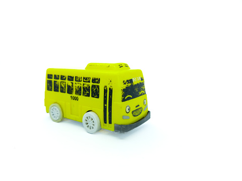 a yellow toy bus, on a plain white background