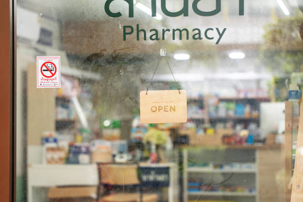 Close up of open sign on glass door to a pharmacy shop