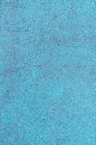 A full frame view of painted concrete highlighting the texture of the surface of the material.