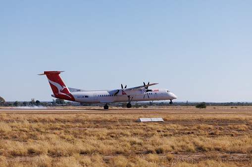 Longreach, Queensland - 29 June 2021: QantasLink Bombardier DHC-8 touching down at Longreach Airport (LRE) in outback Queensland