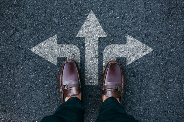 istock Businessman standing on road with three direction arrow choices. 1719861462