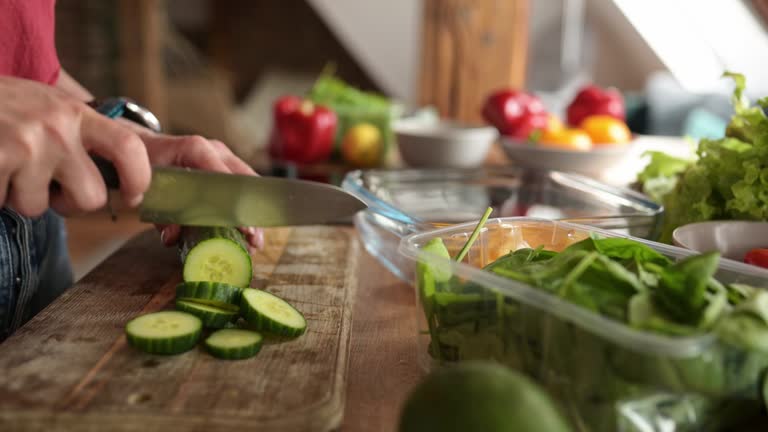 girl cutting a cucumber on a cutting board