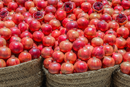 Pile of pomegranate fruit in baskets at food street market, Trapani, Italia