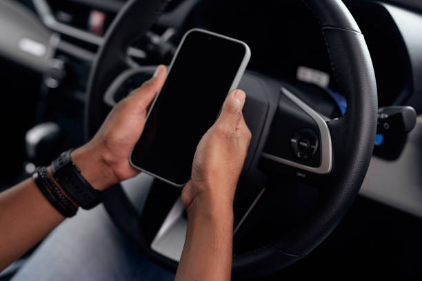 istock Close-up view. Young man using smartphone blank screen in car 1719897308