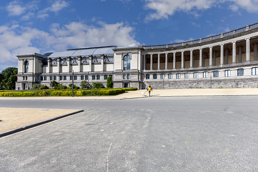 Buenos Aires Belgrano area Sworn Junior college building on a clear Springtime day. This panoramic view also features the cobblestone street in front of the gate and a school bus parked in the shade.