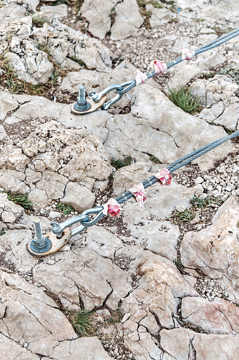 Fastening of suspension bridge braces into rock with large metal anchors closeup. Support equipment screwed into stones at mountain climbing park