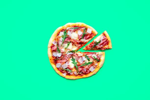 istock Homemade pizza with prosciutto, above view on a green table 1719941159