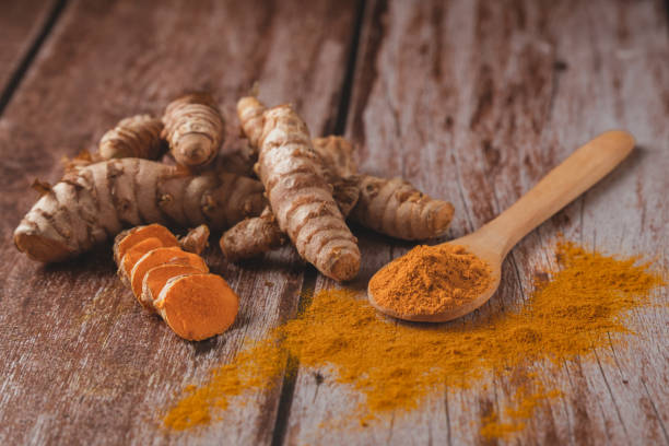 istock fresh turmeric root and ground turmeric in a wooden spoon 1719945516
