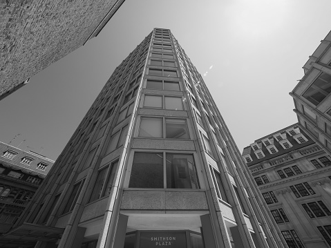Black and white reflection of office buildings on the glass wall, background with copy space, full frame horizontal composition
