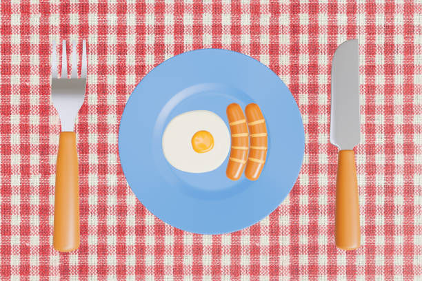 Yellow fried eggs and fried sausage on a round plate with fork and spoon healthy breakfast