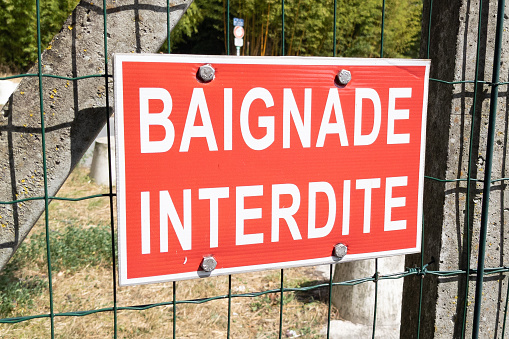 baignade interdite french text sign near river lake beach means prohibited no swimming