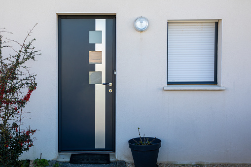 new modern gray door with aluminum entrance to the house facade