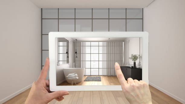 istock Augmented reality concept. Hand holding tablet with AR application used to simulate furniture and design products in empty interior with parquet floor, modern bathroom with bathtub 1720026376