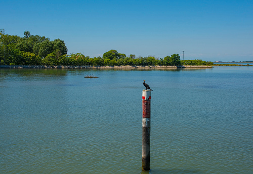 A channel marker shows the edge of a navigable channel in the shallow waters in the Grado section of the Marano and Grado Lagoon in Friuli-Venezia Giulia, north east Italy. August