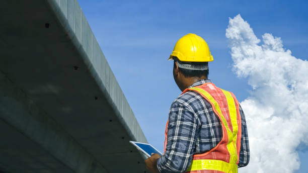 istock Asian foreman using tablet to record electronic data on construction site of concrete highway bridge. Inspection project road construction development. 1720038713