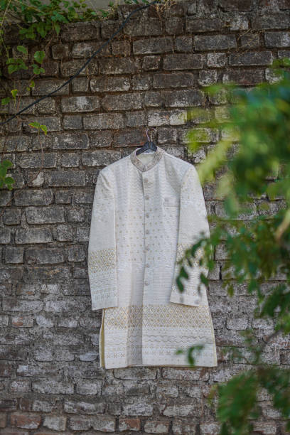 istock Indian groom`s wedding sherwani hanging on frame 1720038749
