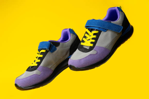 istock Violet-blue female sneakers on yellow studio background 1720050240