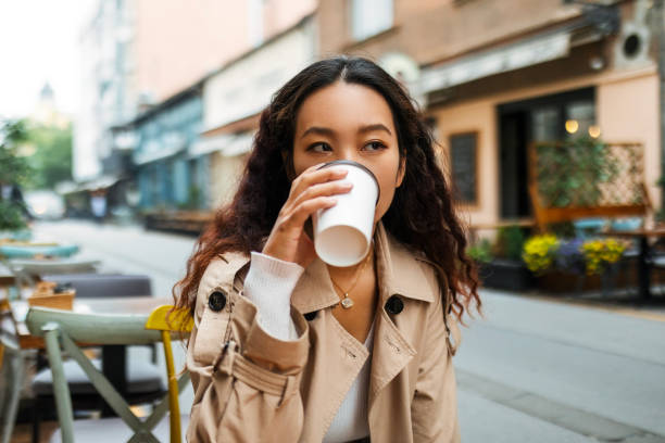 istock Young Asian Woman Relaxes with Coffee at a Sidewalk Cafe 1720061239