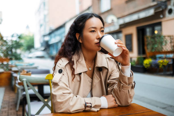 istock Young Asian Woman Takes a Break at a Sidewalk Cafe 1720061240