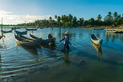 A woman is dragging and nailing wooden fishing boats, which made a flower shape on O Loan lagoon - Phu Yen province, central Vietnam