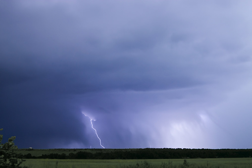 Lightning strike in the night sky with rain and lightning in the background