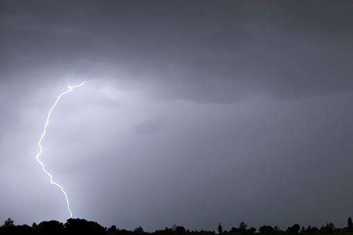 Lightning strike in the night sky with rain and lightning in the background