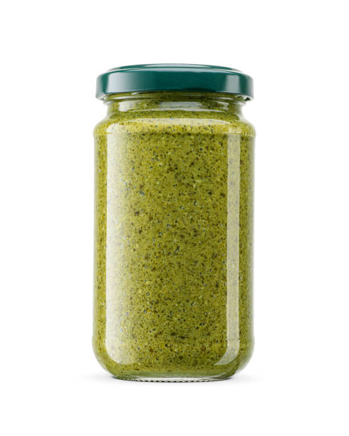 유리 병에 담긴 녹색 이탈리아 소스 페스토는 금속으로 꼬인 뚜껑을 흰색으로 분리합니다. - jar pesto sauce packaging food 뉴스 사진 이미지