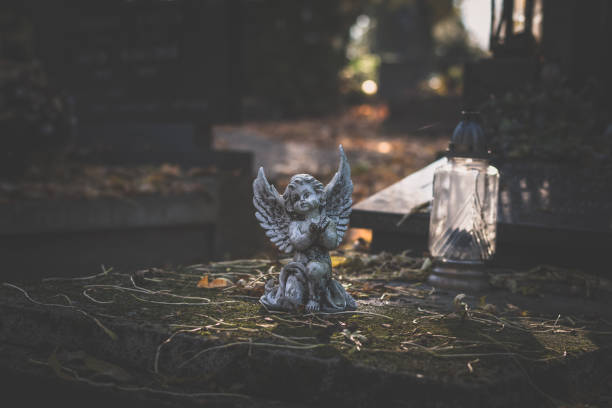 guardian angel statue on the grave in sad autumnal time