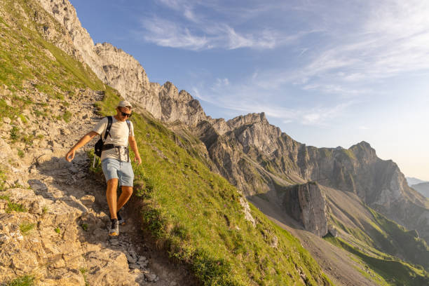 istock Man hikes along a mountain ridge in the bright sun 1720141898