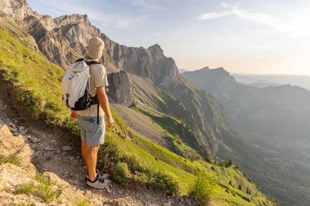 istock Man hikes along a mountain ridge in the bright sun 1720141899
