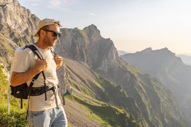 istock Man hikes along a mountain ridge in the bright sun 1720141914