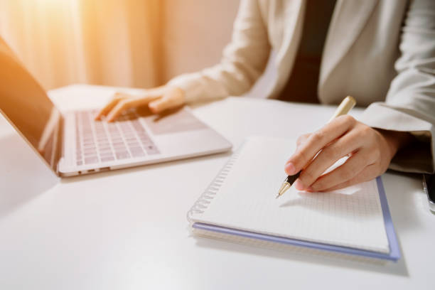 istock Close-up view of young professional businessman writing his idea concepts on notebook while working on his project 1720161983