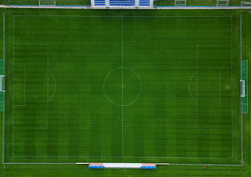 sports stadium football match with several goals. the children here have a series of elimination school grade matches. observe the swarm vertically downwards. mowed stripes lawn, football stadium