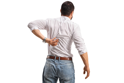 Rear view shot of a man holding his stiff back isolated on white background